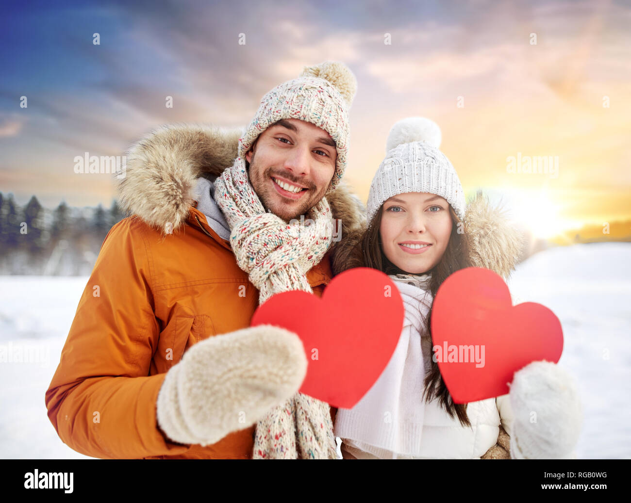 Glückliches Paar mit roten Herzen über winter natur Stockfoto