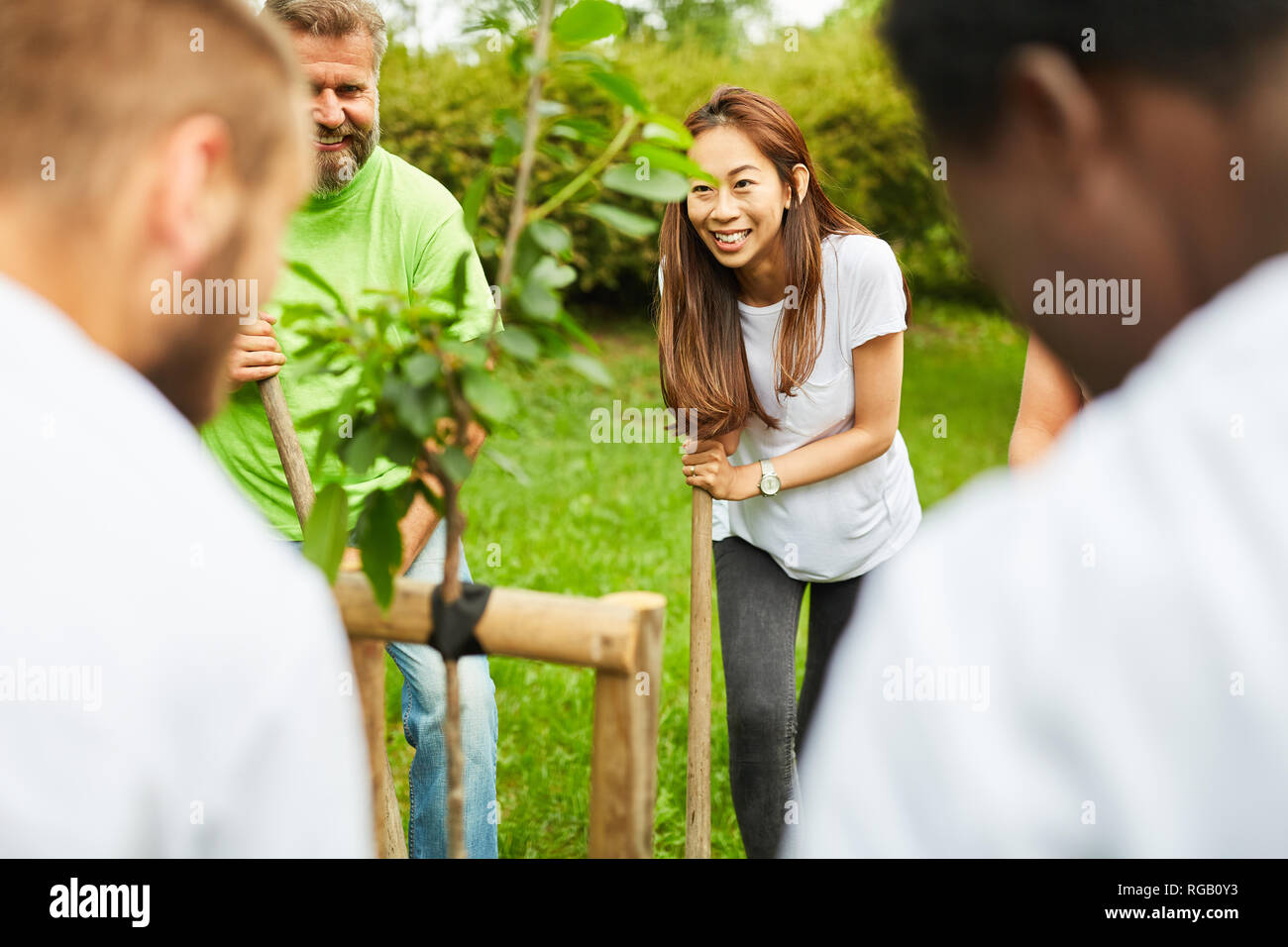 Gruppe der jungen Naturschützer beim Pflanzen einen Baum im Park oder Garten Stockfoto