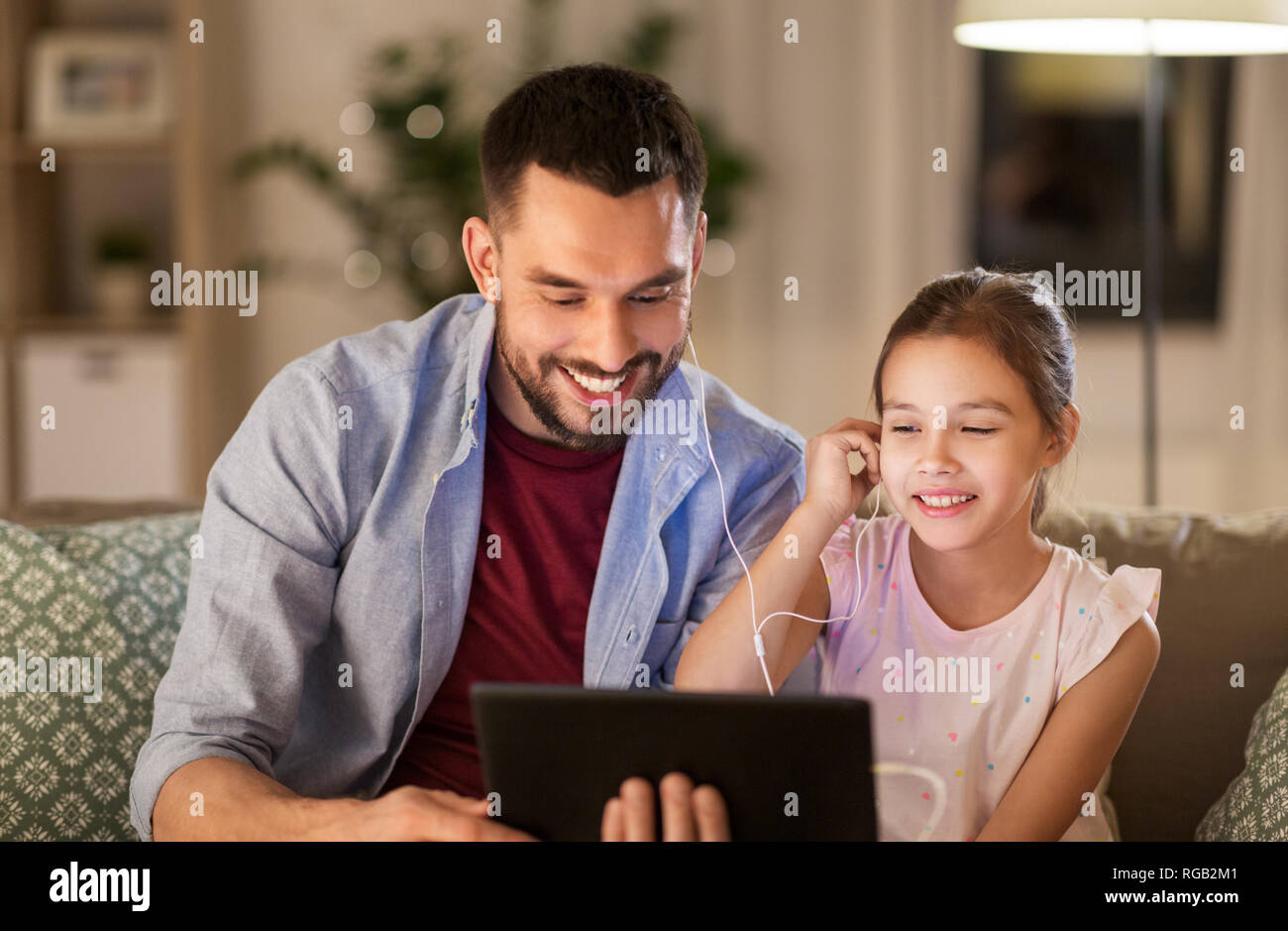 Vater und Tochter hören die Musik auf Tablet Stockfoto