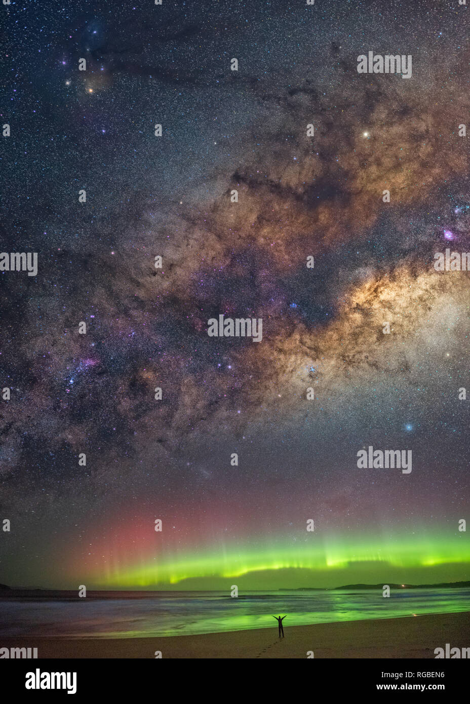 Einsame Abbildung in Silhouette, stehend staunend mit Waffen unter der Aurora und Milchstraße ausgestreckten Stockfoto