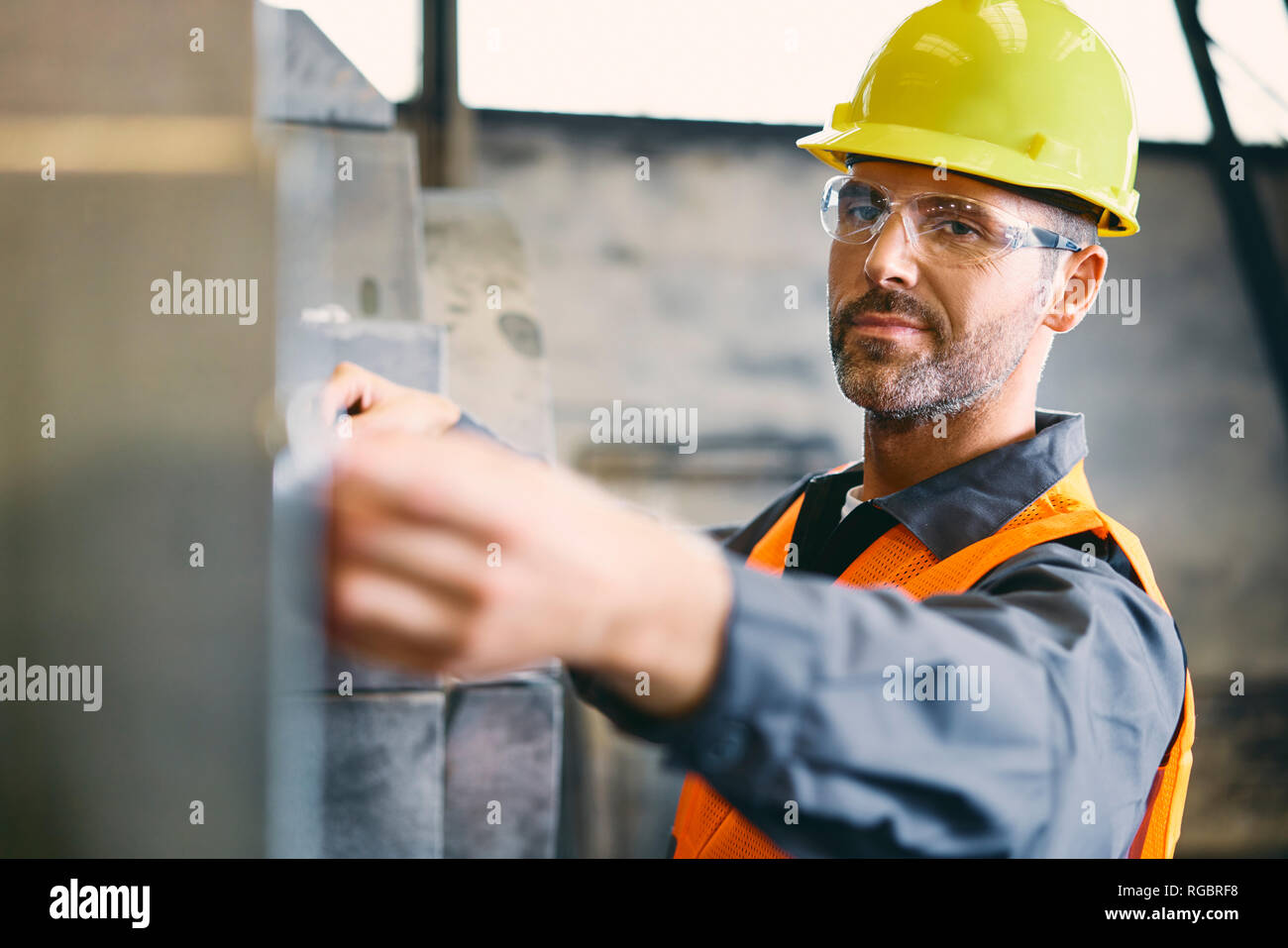 Portrait von zuversichtlich Mann tragen von Arbeitskleidung in der Fabrik arbeiten Stockfoto