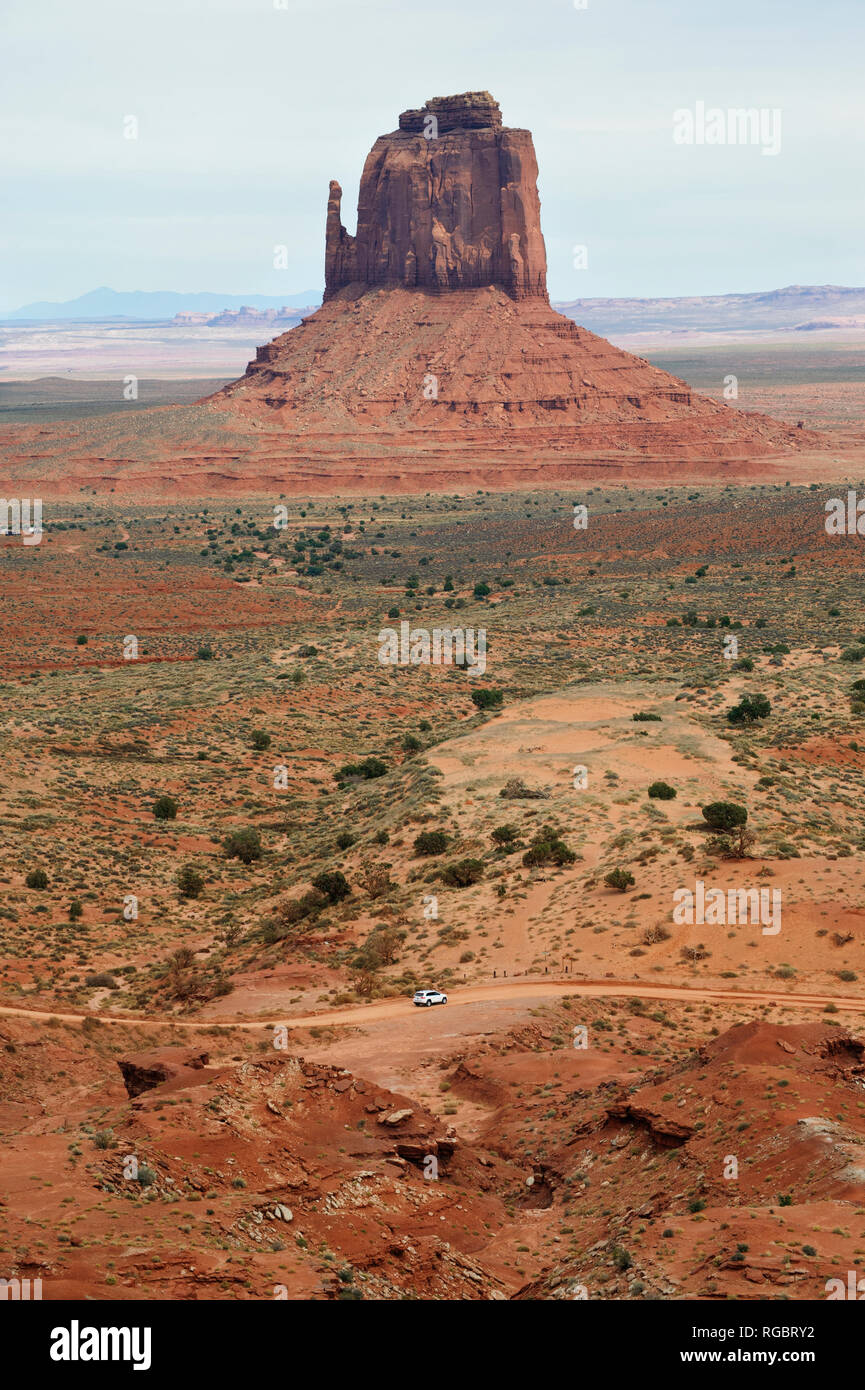 Weiß SUV fahren auf einer Piste im Monument Valley, Arizona, mit den rechten Handschuh im Hintergrund. Stockfoto