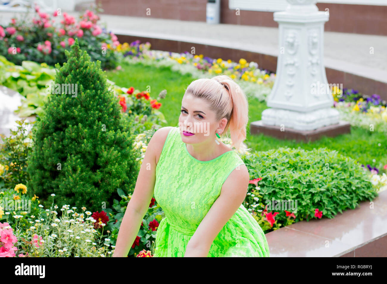 Eine Frau sitzt in der schönen Blumenschmuck, das Thema der schönen lebendigen Frauen Stockfoto