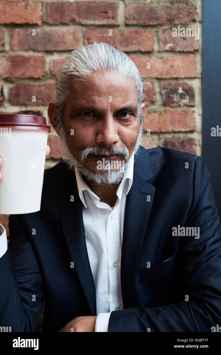Portrait von bärtigen älteren Geschäftsmann mit Coffee to go Stockfoto