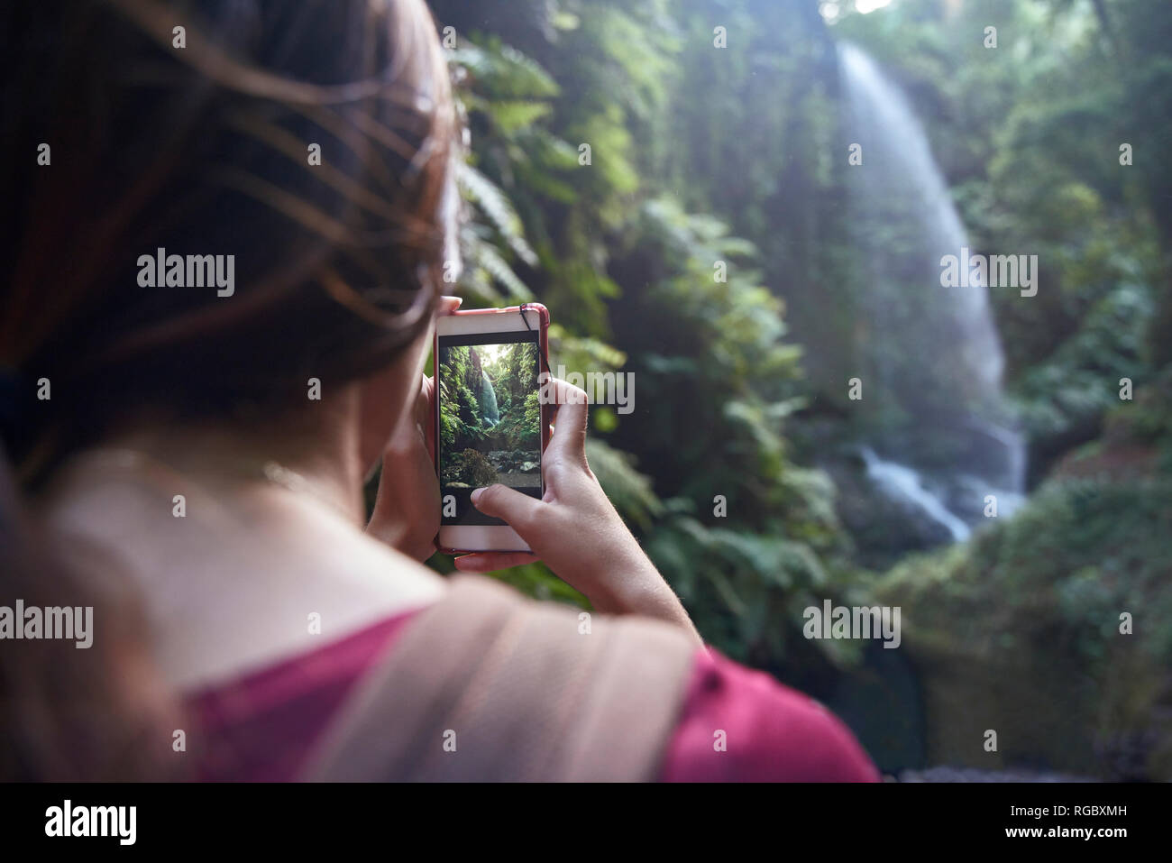 Spanien, Kanarische Inseln, La Palma, Frau ein Handy Bild von einem Wasserfall im Wald Stockfoto