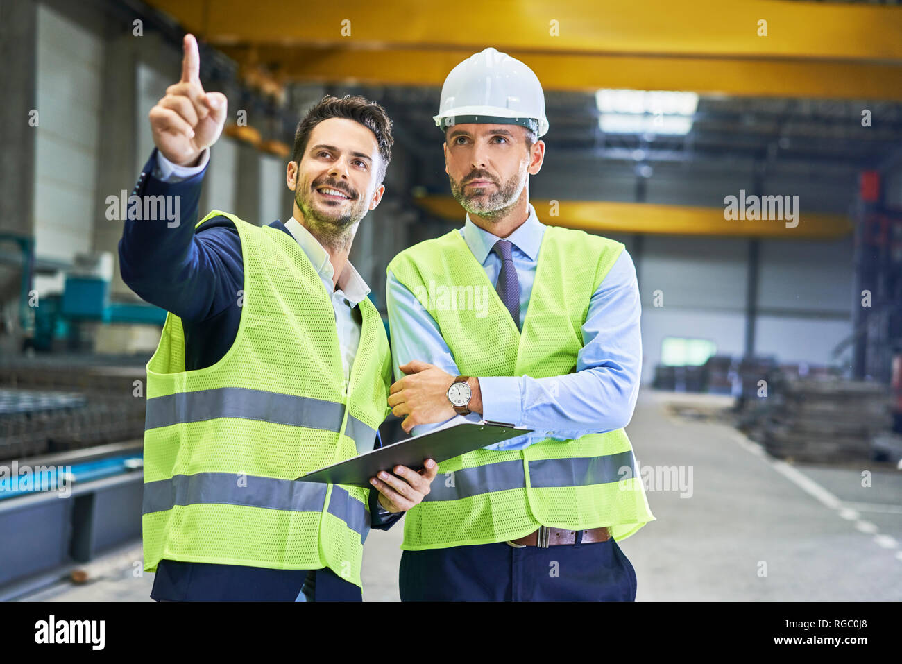 Zwei Manager tragen von Arbeitskleidung sprechen in der Factory Stockfoto
