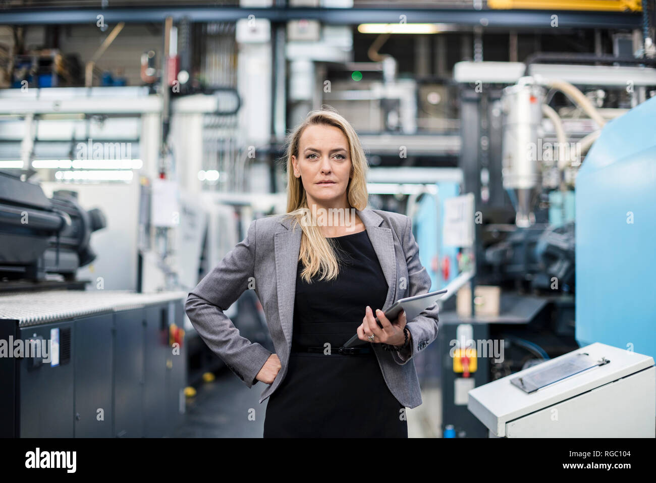 Portrait von selbstbewusste Frau, die Tablette im Factory Shop Boden Stockfoto