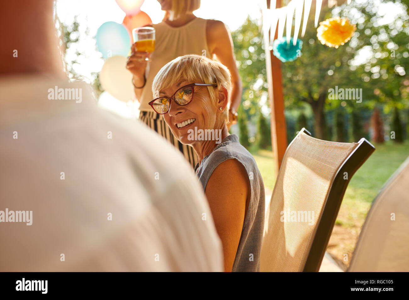 Lächelnd reife Frau zu Mann auf einer Gartenparty suchen Stockfoto