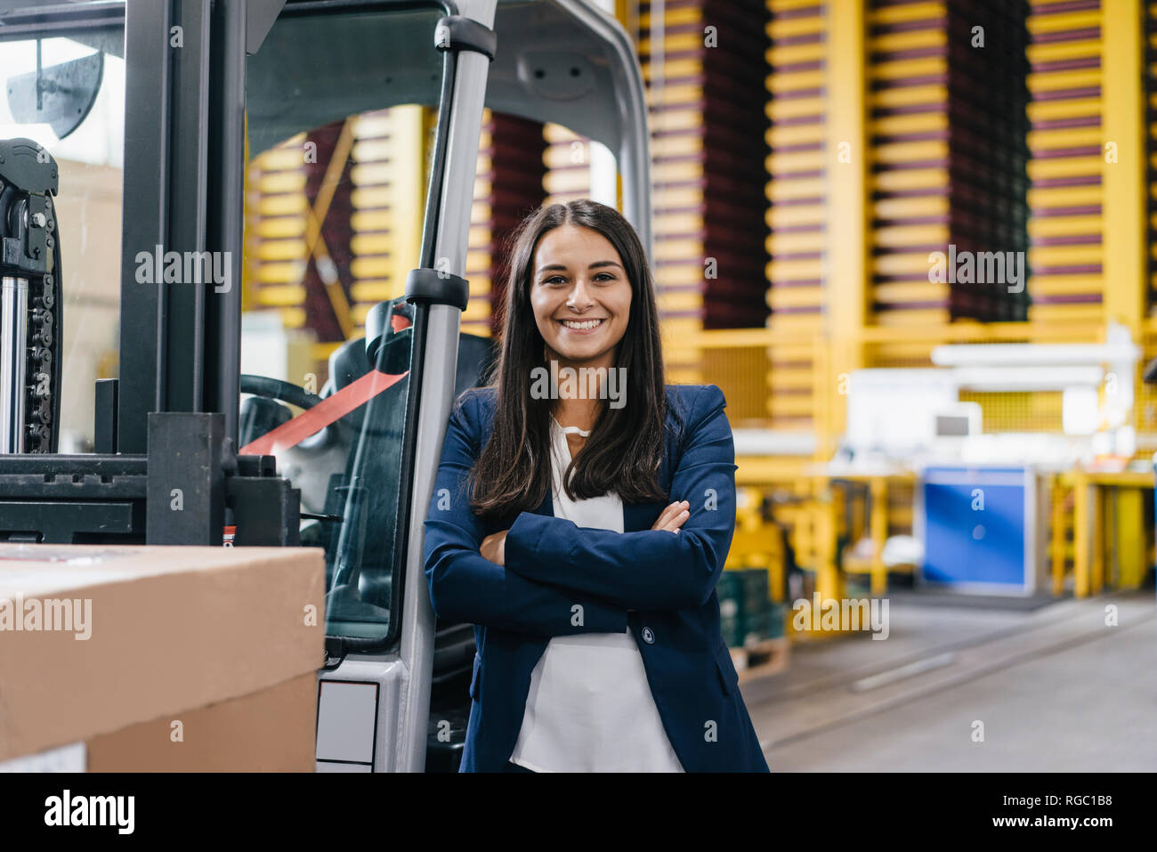 Selbstbewusste Frau im Logistikzentrum, mit verschränkten Armen Stockfoto