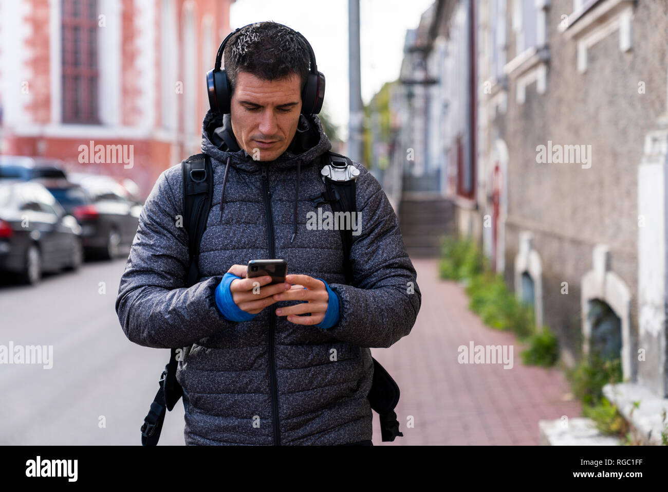 Der Mensch in der Stadt unterwegs mit Handy und Kopfhörer Stockfoto