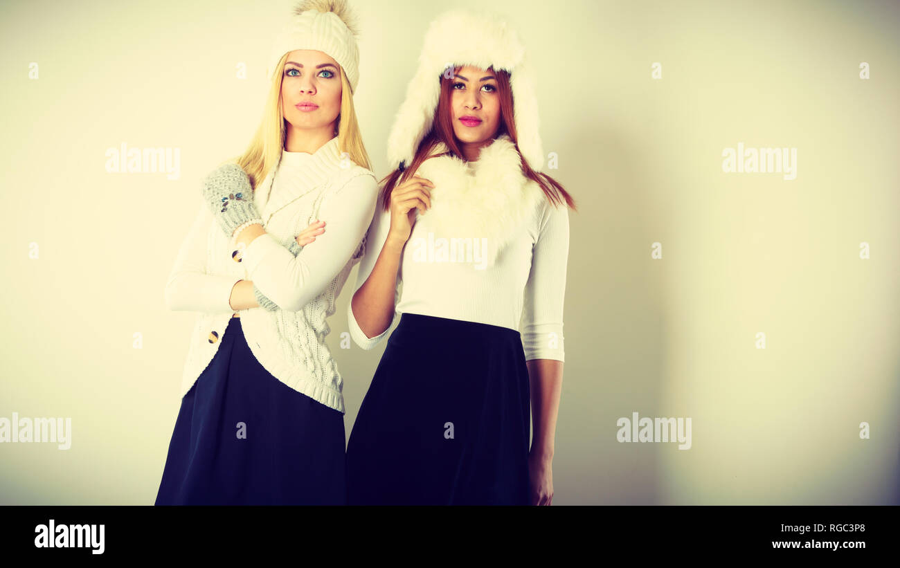 Fashion Modelle Personen Konzept. Zwei Frauen mit Winterkleidung. Blond und Mixed Race Damen tragen warme Kleidung. Stockfoto