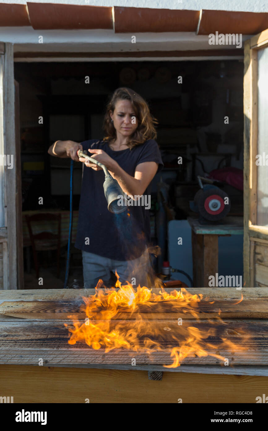 Handwerkerin das Verbrennen von Holz in ihrem Workshop Stockfoto