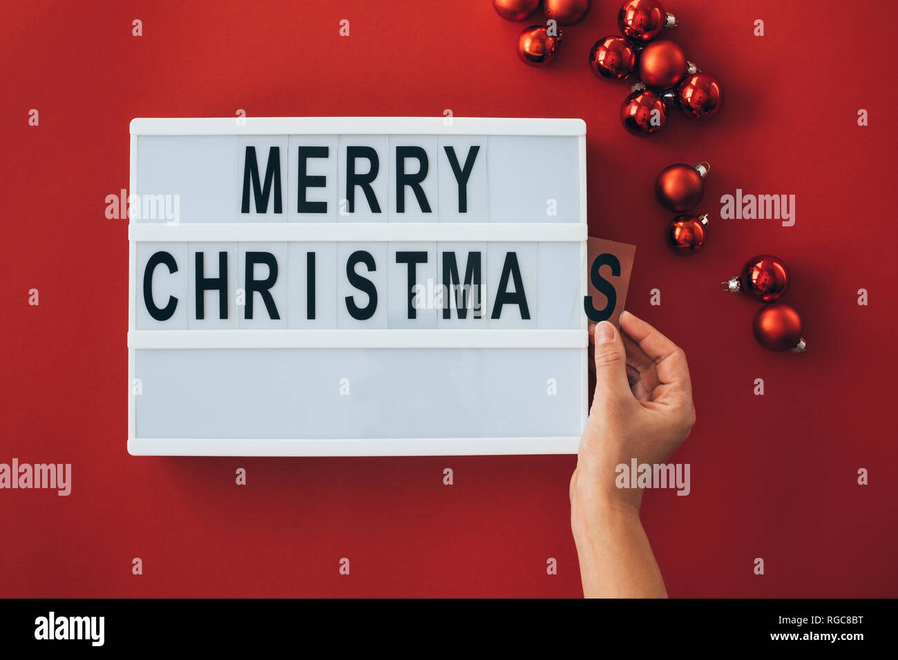 Die Frau Hände hinzufügen von Buchstaben bei "Frohe Weihnachten!" Zeichen Stockfoto