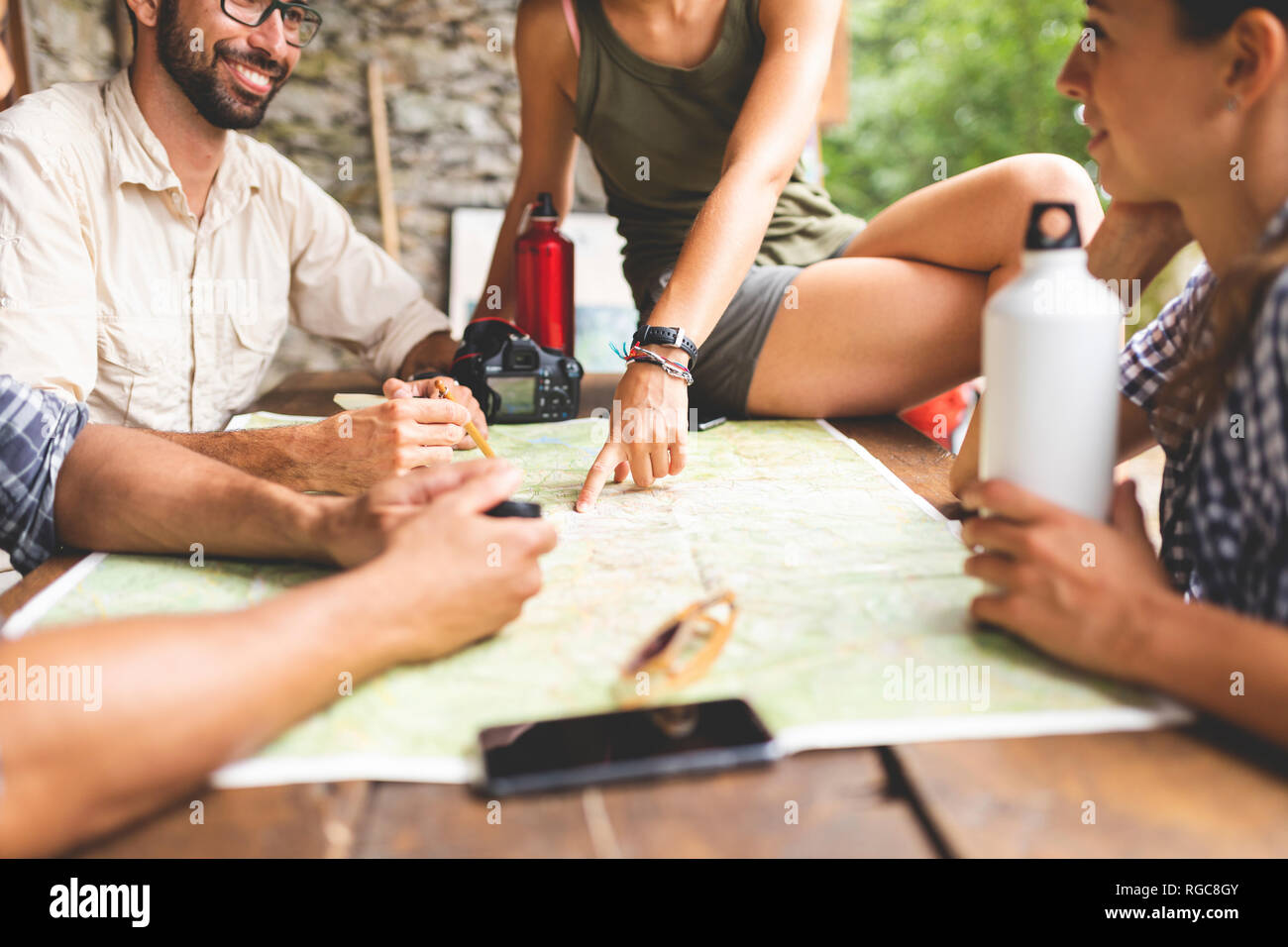 Gruppe der Wanderer sitzen gemeinsam wandern Route auf Karte suchen Stockfoto