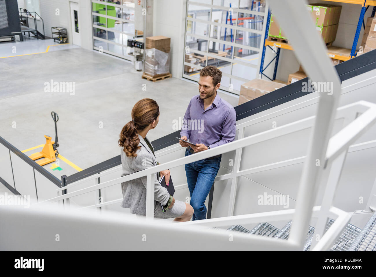 Busenessman und Frau auf Treppe in Unternehmen, Reden Stockfoto