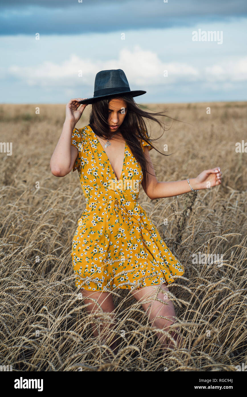 Junge Frau Sommer Kleid mit Blumenmuster und einem Hut tanzen im Maisfeld Stockfoto