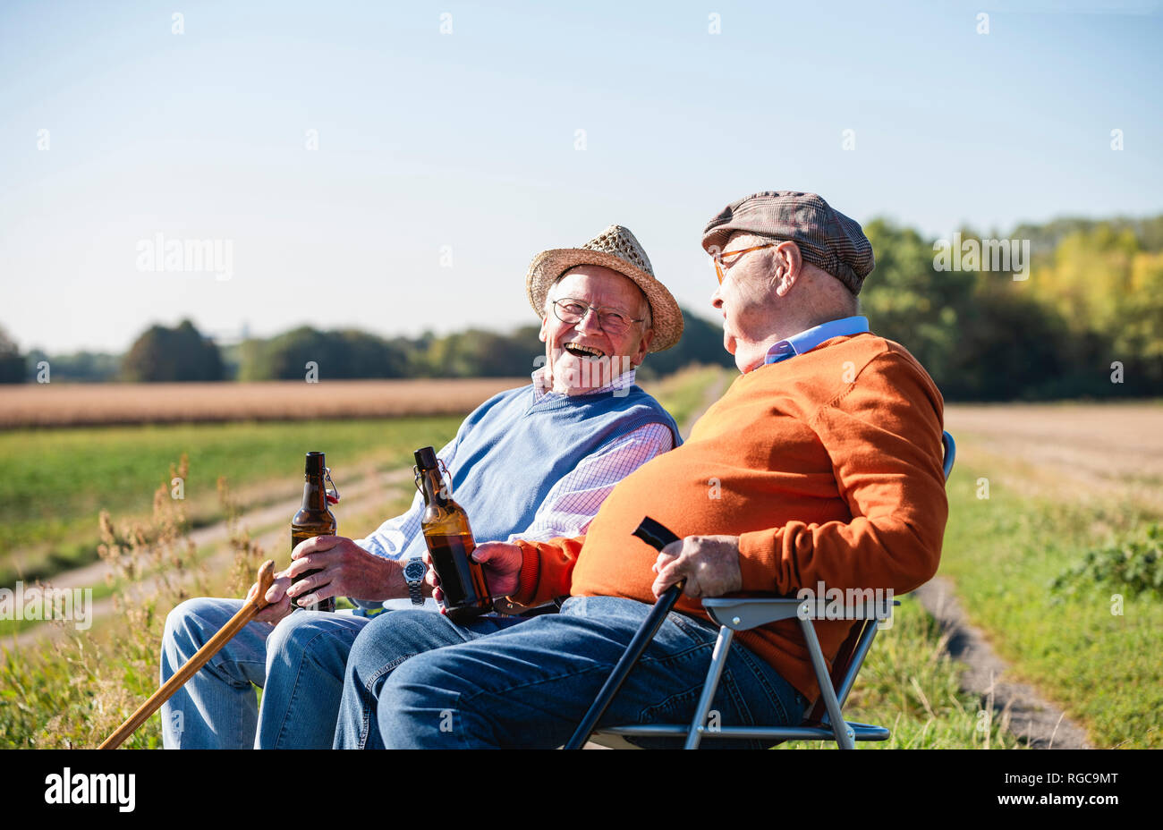 Zwei alte Freunde sitzen in die Felder, Bier und Reden über alte Zeiten  Stockfotografie - Alamy