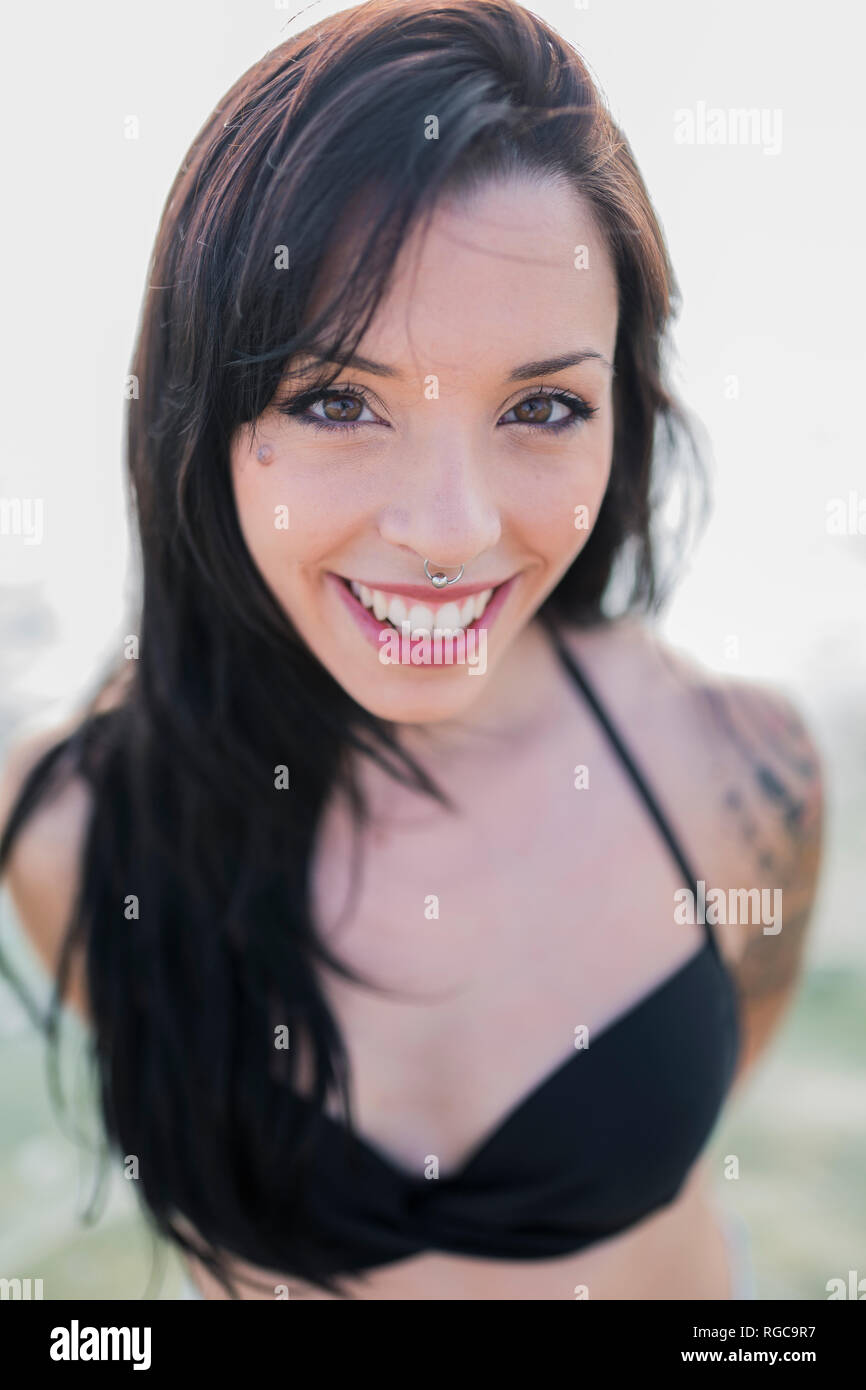Portrait von lächelnden jungen Frau mit nasenpiercing am Meer Stockfoto