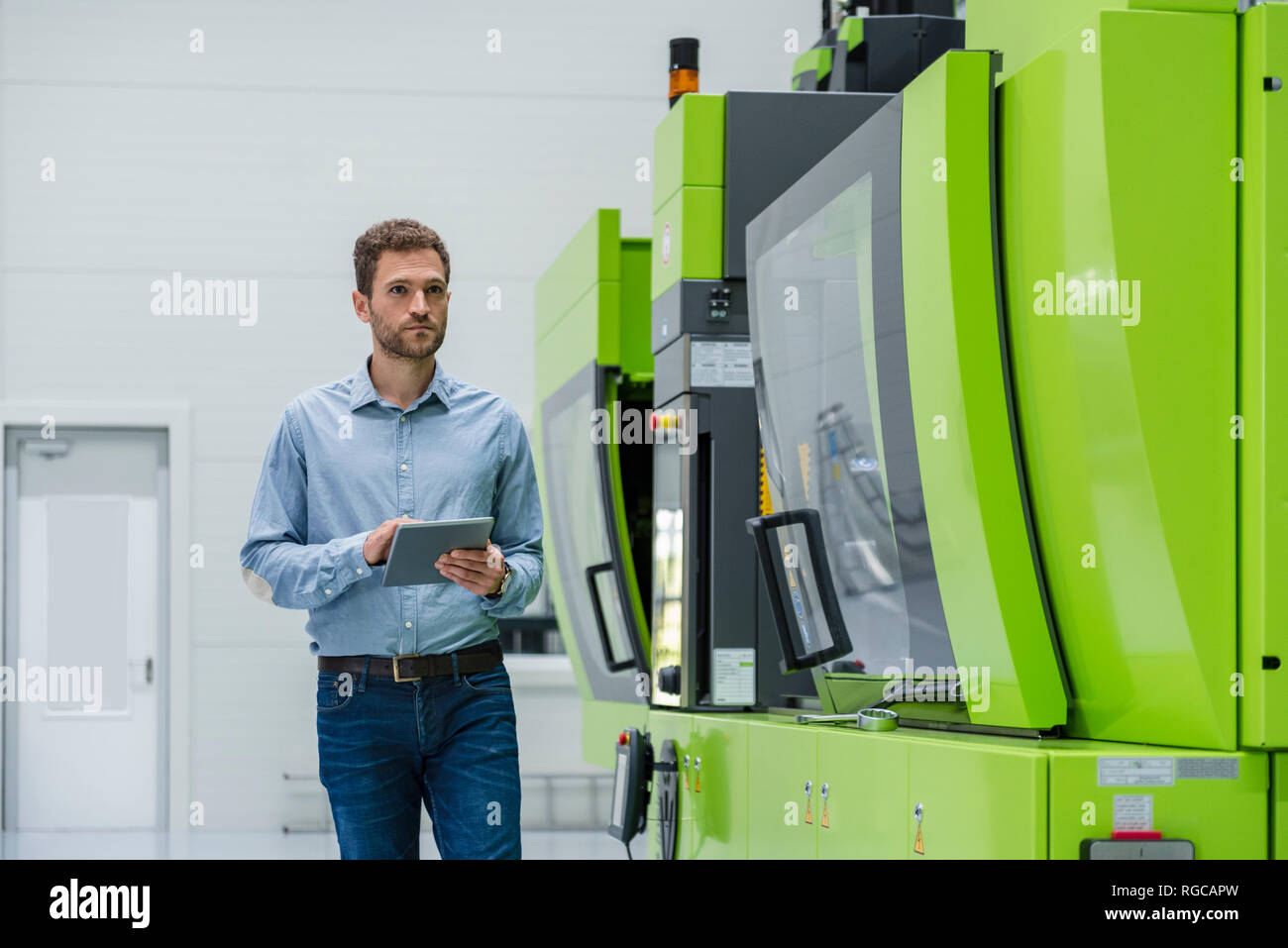 Unternehmer in High-Tech Unternehmen controlling Fertigung Maschinen, mit digitalen Tablet Stockfoto