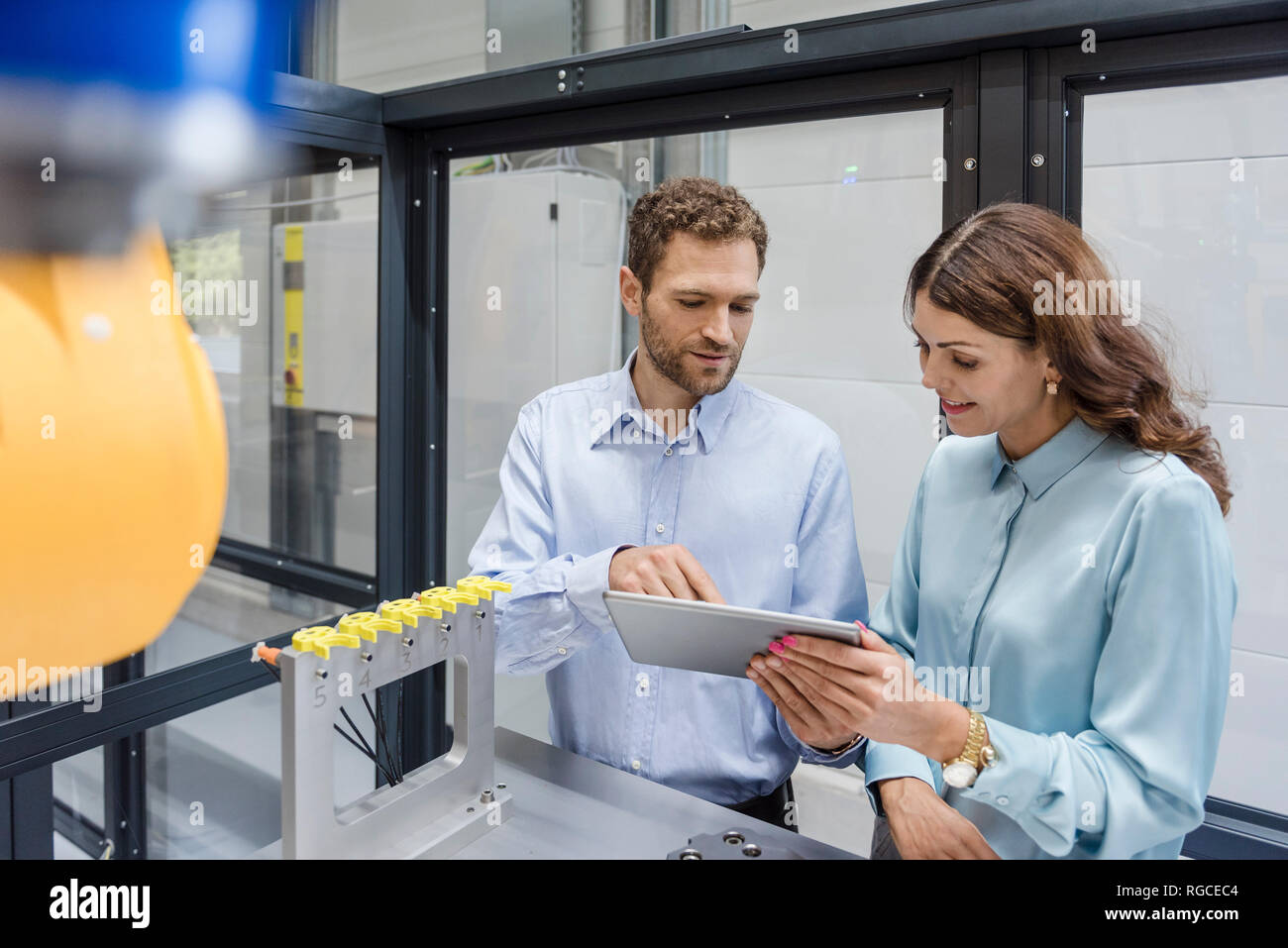 Kollegen in High-Tech Unternehmen controlling Fertigung Maschinen, mit digitalen Tablet Stockfoto