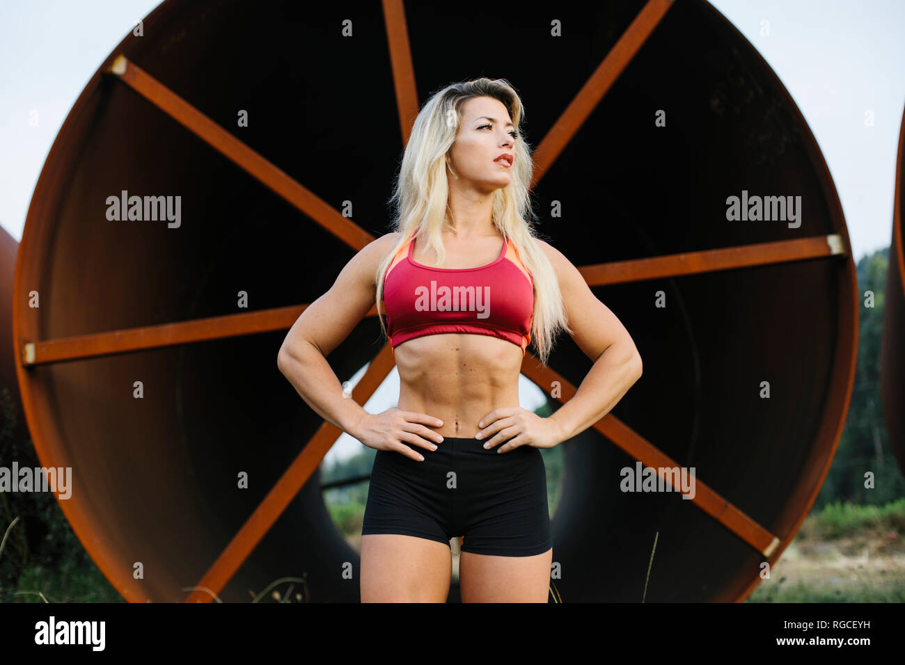 Zuversichtlich athletische Frau stehend an Industrial Site Stockfoto