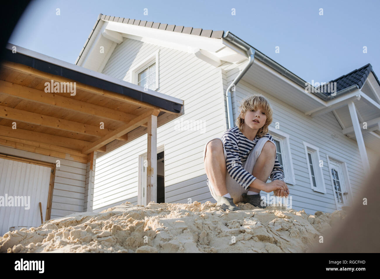 Porträt der blonde Junge spielt in der Nähe der Baustelle für ein freistehendes Einfamilienhaus Stockfoto