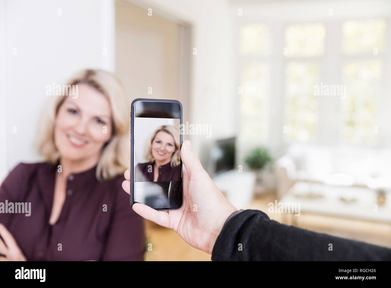 Mann, Foto von Frau mit Smartphone zu Hause, close-up Stockfoto