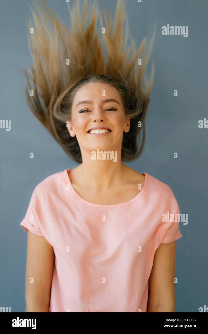 Porträt der lächelnde junge Frau wirft ihr Haar Stockfoto