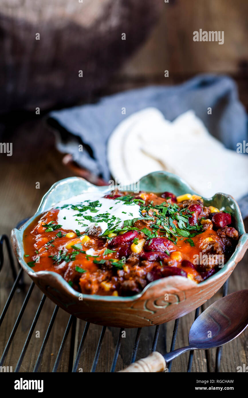 Chili con carne mit Bohnen und Mais, saure Sahne, Petersilie, Tortilla Brot Stockfoto