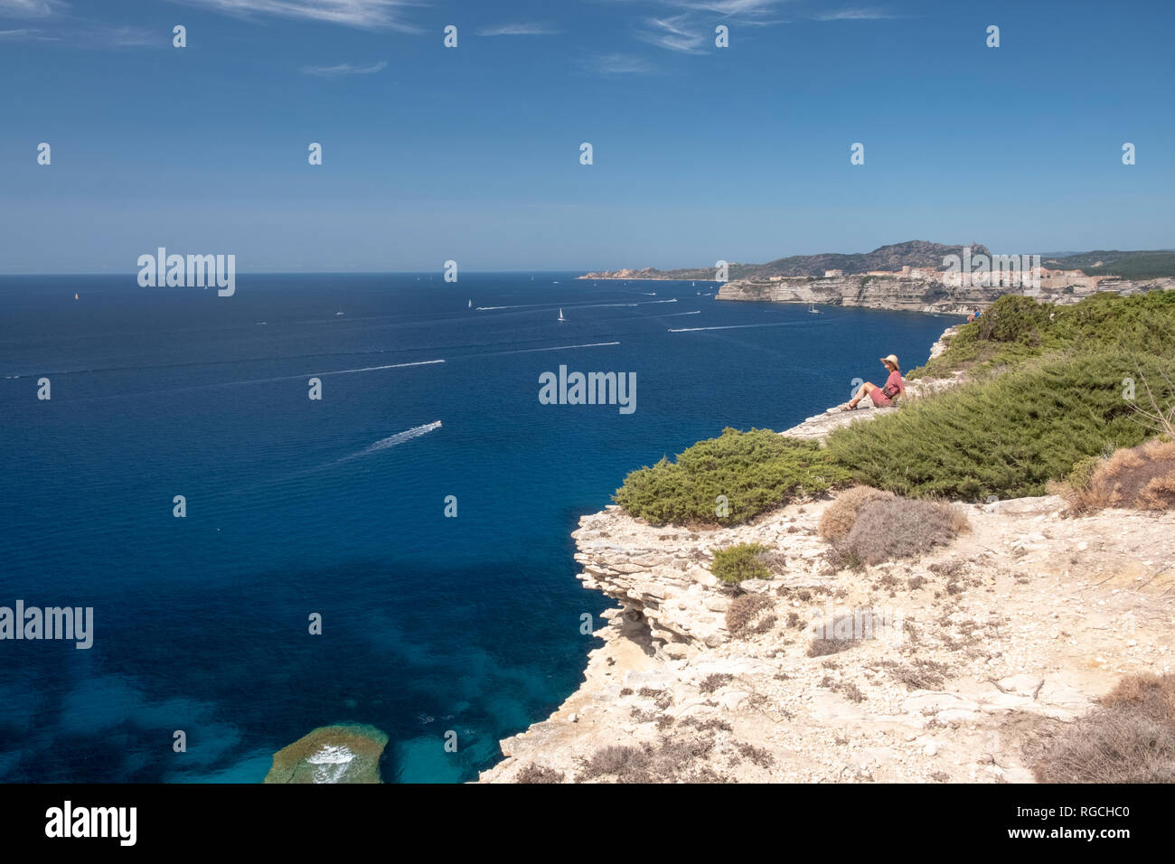 Korsika, Mittelmeer, Frau sitzt auf der felsigen Klippen Stockfoto