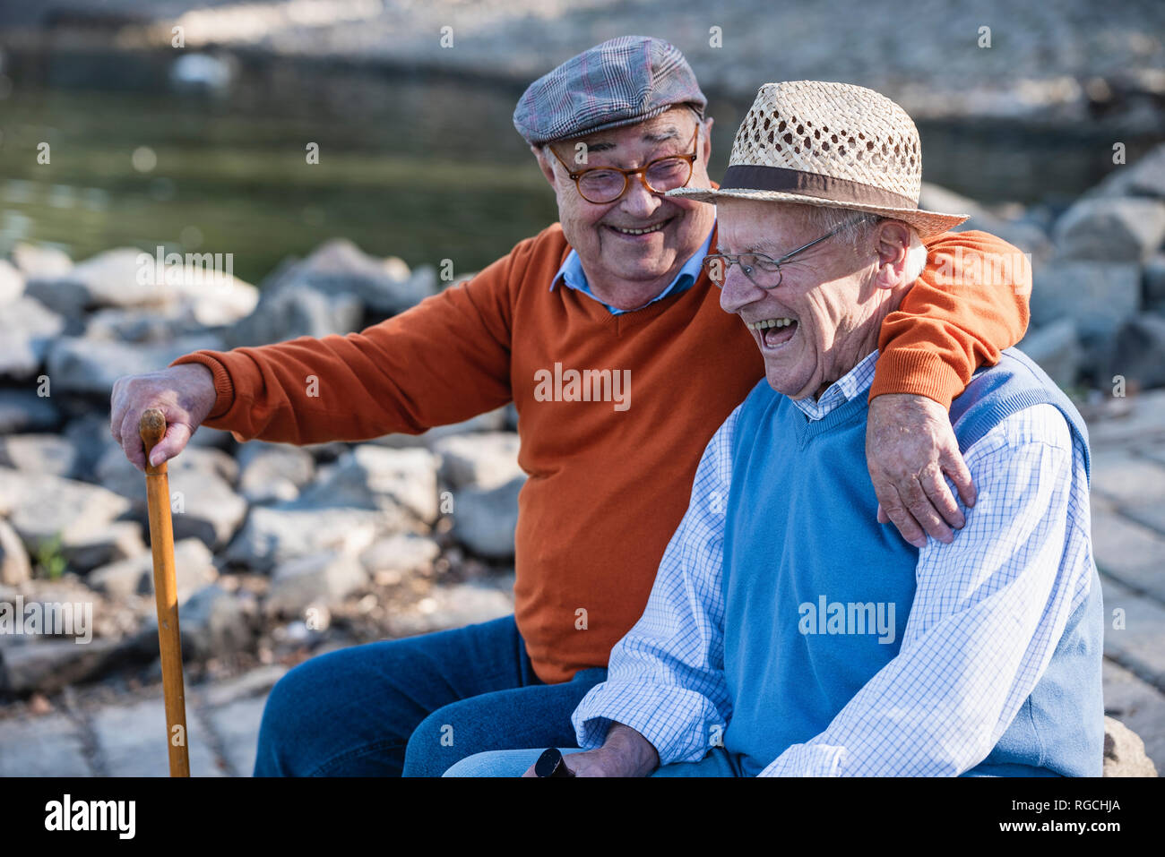 Zwei alte Freunde sitzen am Flussufer, Spaß Stockfoto