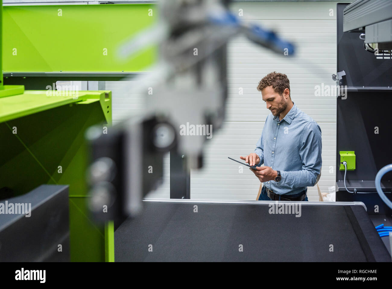 Unternehmer in High-Tech Unternehmen controlling Fertigung Maschinen, mit digitalen Tablet Stockfoto