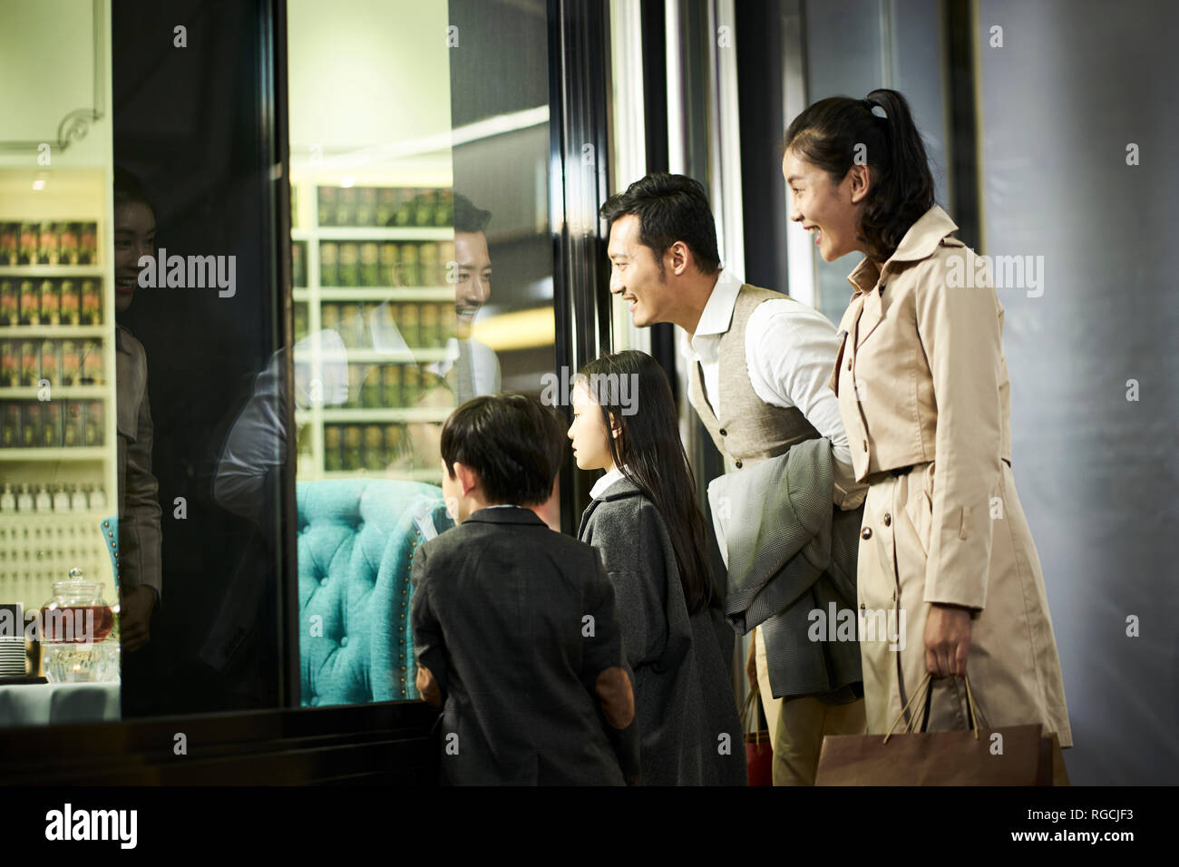 Gerne asiatische Familie mit zwei Kindern, in einem Schaufenster in der Shopping Mall Stockfoto