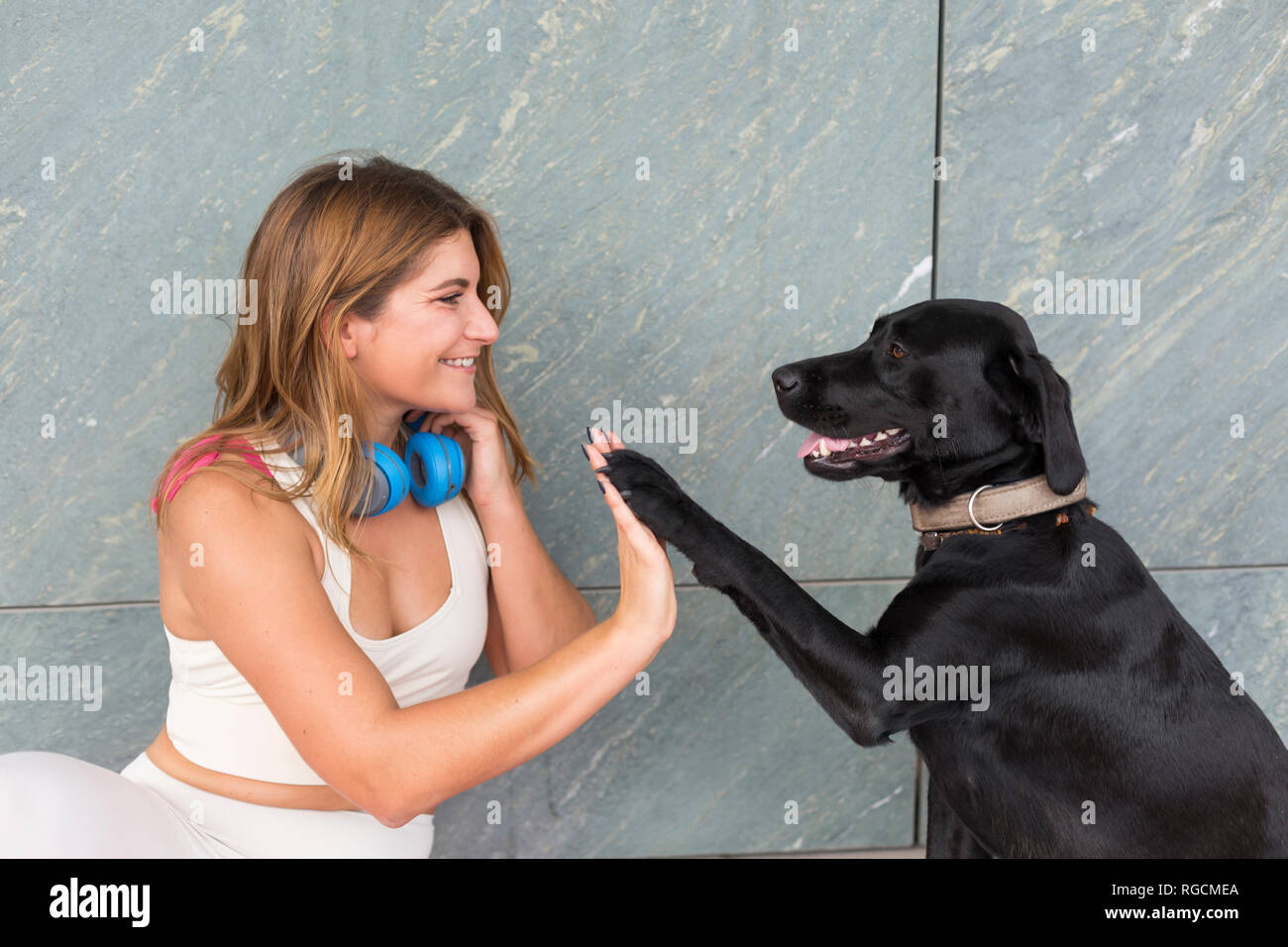 Glückliche junge Frau mit ihrem schwarzen Hund Stockfoto