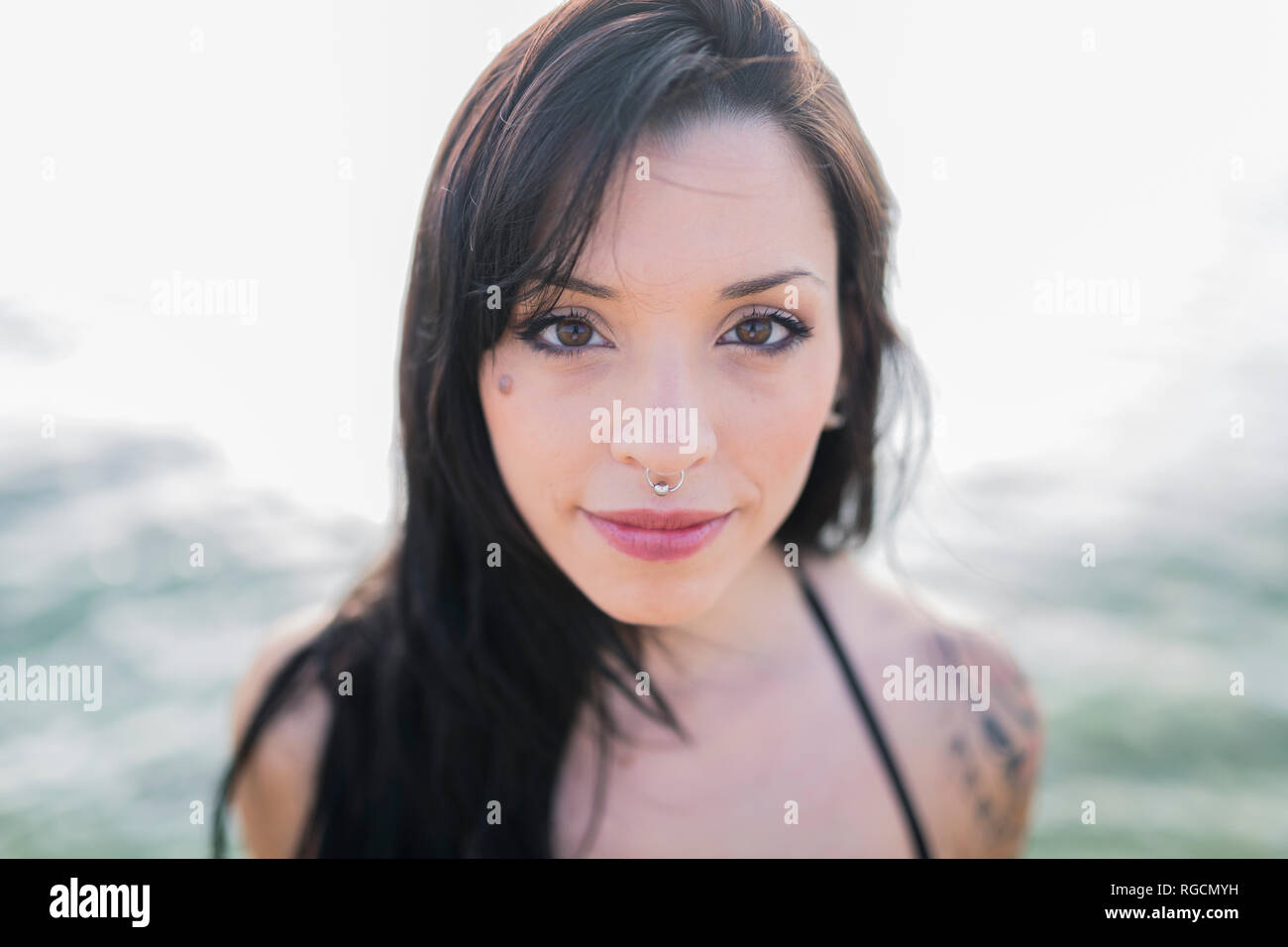 Portrait von lächelnden jungen Frau mit nasenpiercing am Meer Stockfoto