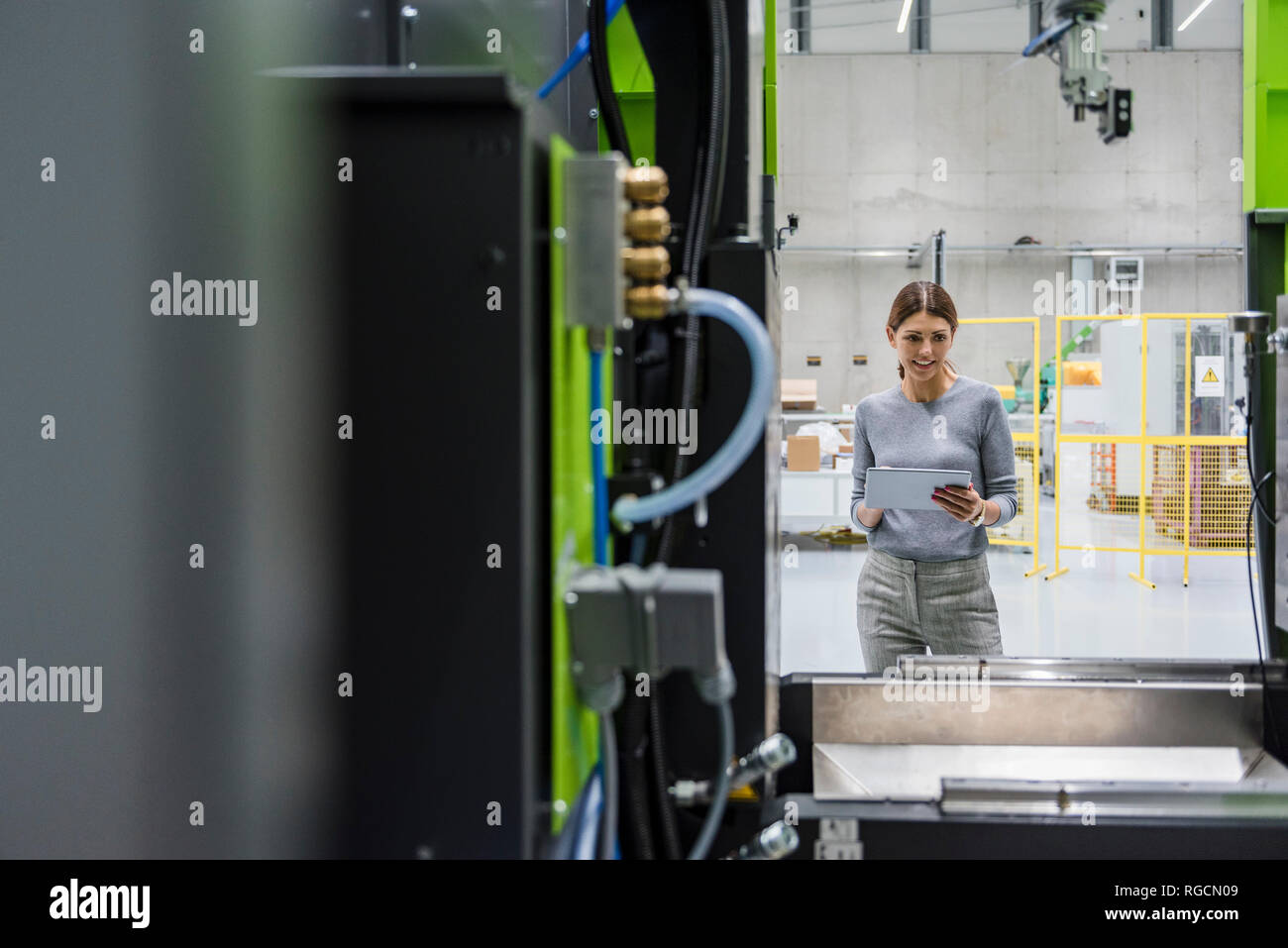 In High-Tech-Unternehmen, das Maschinen zur Herstellung von Geschäftsfrau, mit digitalen Tablet Stockfoto