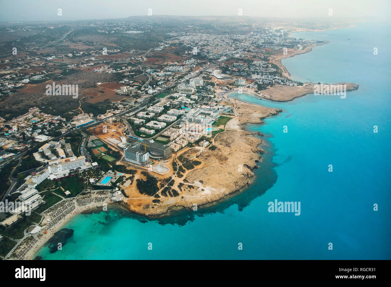 Zypern wunderschöne Küste, Mittelmeer, türkis Farbe. Häuser an der Küste des Mittelmeers. Touristische Stadt mit einem langen Strand. Sommerferien eine Stockfoto