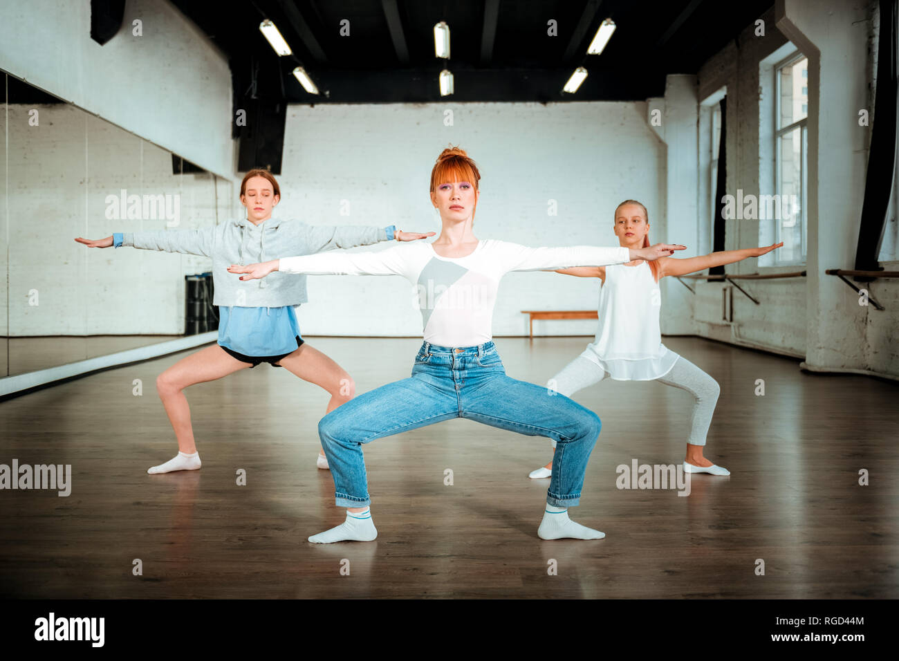 Schlanke schöne Ballett Lehrer tun Hausbesetzung mit zwei jungen Studenten Stockfoto