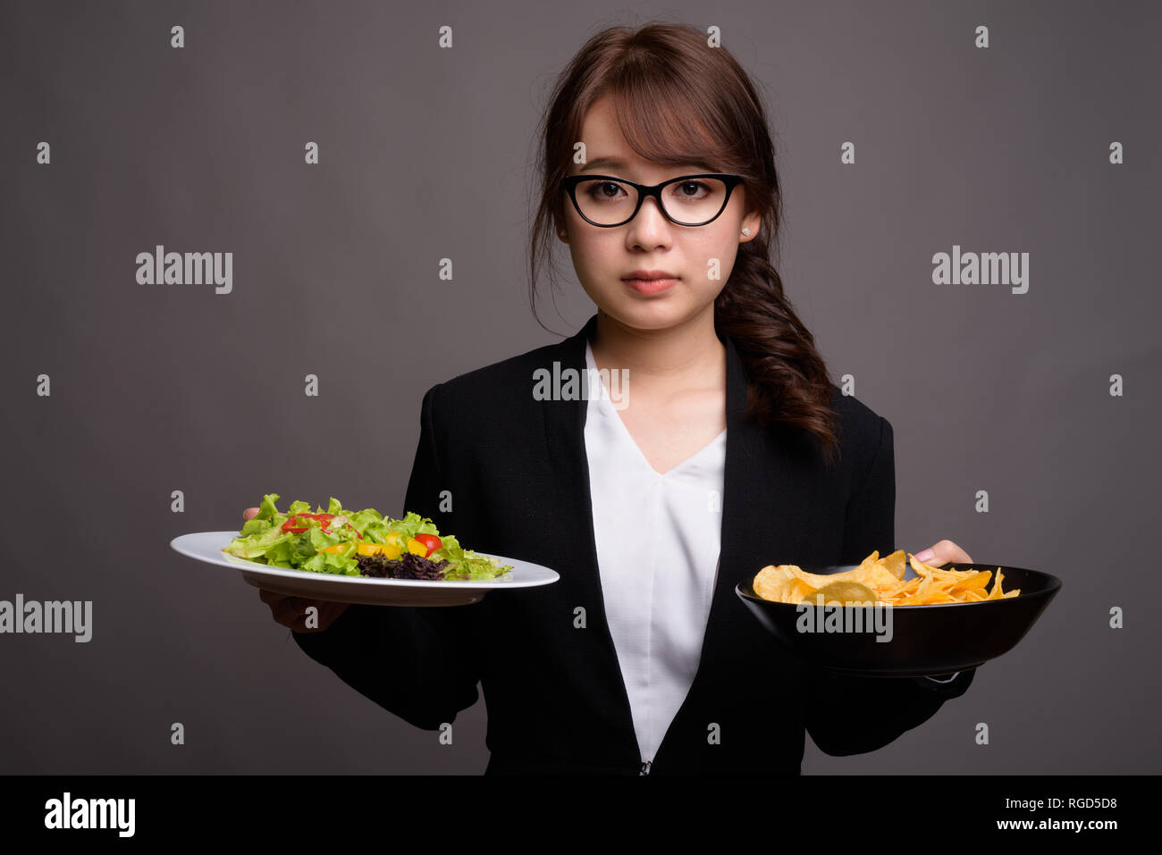 Asiatische Geschäftsfrau mit Salat und Pommes frites Stockfoto