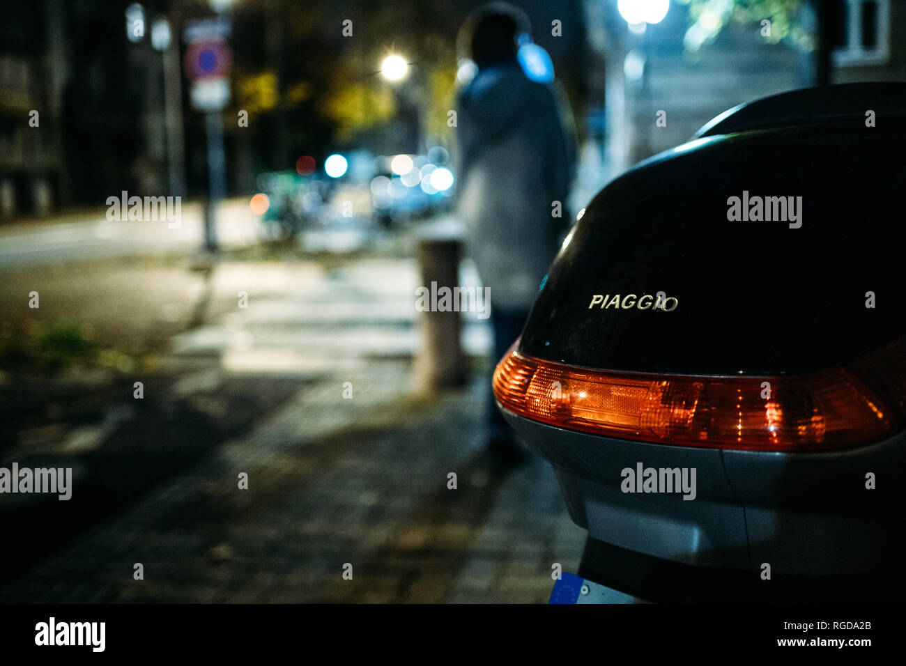 Straßburg, Frankreich - 28 Oktober 2018: Frau Silhouette zu Fuß in der Nähe von Piaggio moped Moto scuter in der französischen Stadt bei Nacht Stockfoto