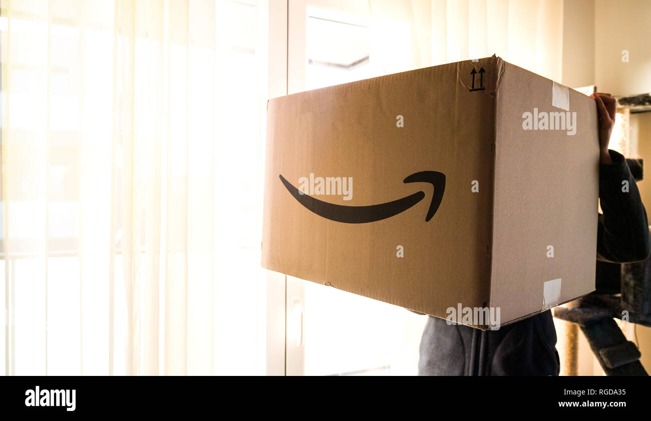 PARIS, Frankreich, 25.Dezember, 2018: Die Frau in der Nähe von Glas Tür  grosse Amazon Prime Paket Karton am Weihnachtstag mit großen riesige  Geschenk innen Stockfotografie - Alamy