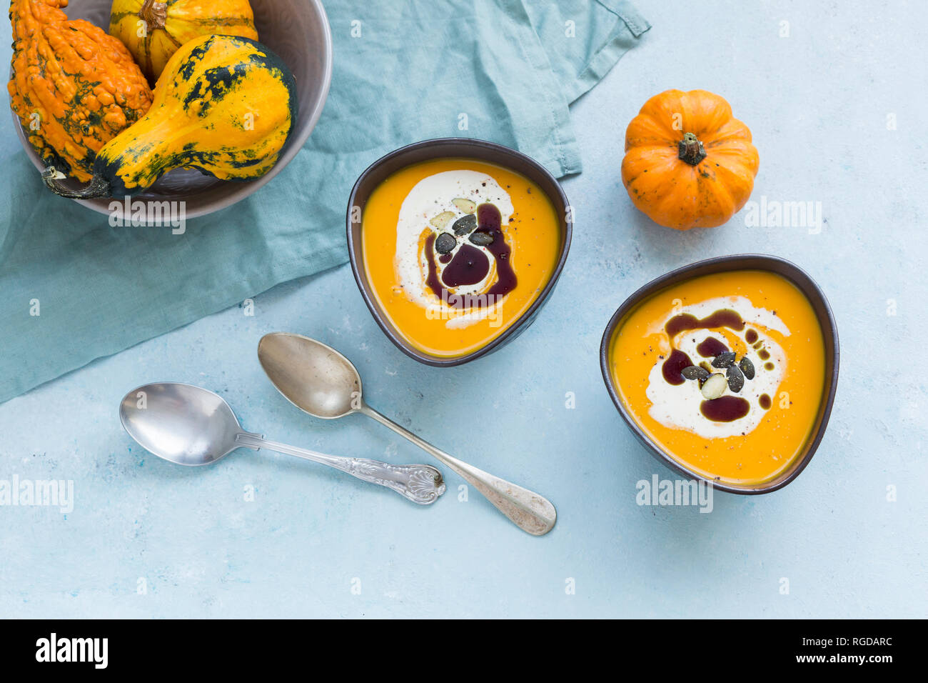 Zwei Schalen mit hausgemachten Hokkaido Kürbis Suppe, garniert mit Sahne, Kürbiskernöl und Kürbiskerne Stockfoto