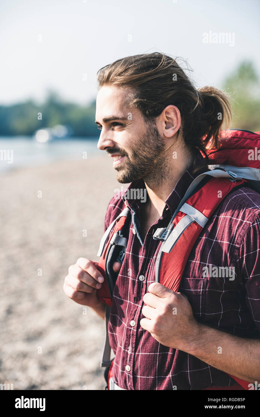 Lächelnden jungen Mann mit Rucksack im Freien Stockfoto