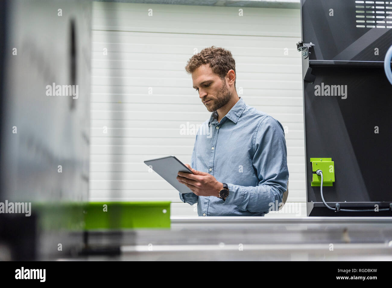 Unternehmer in High-Tech Unternehmen controlling Fertigung Maschinen, mit digitalen Tablet Stockfoto