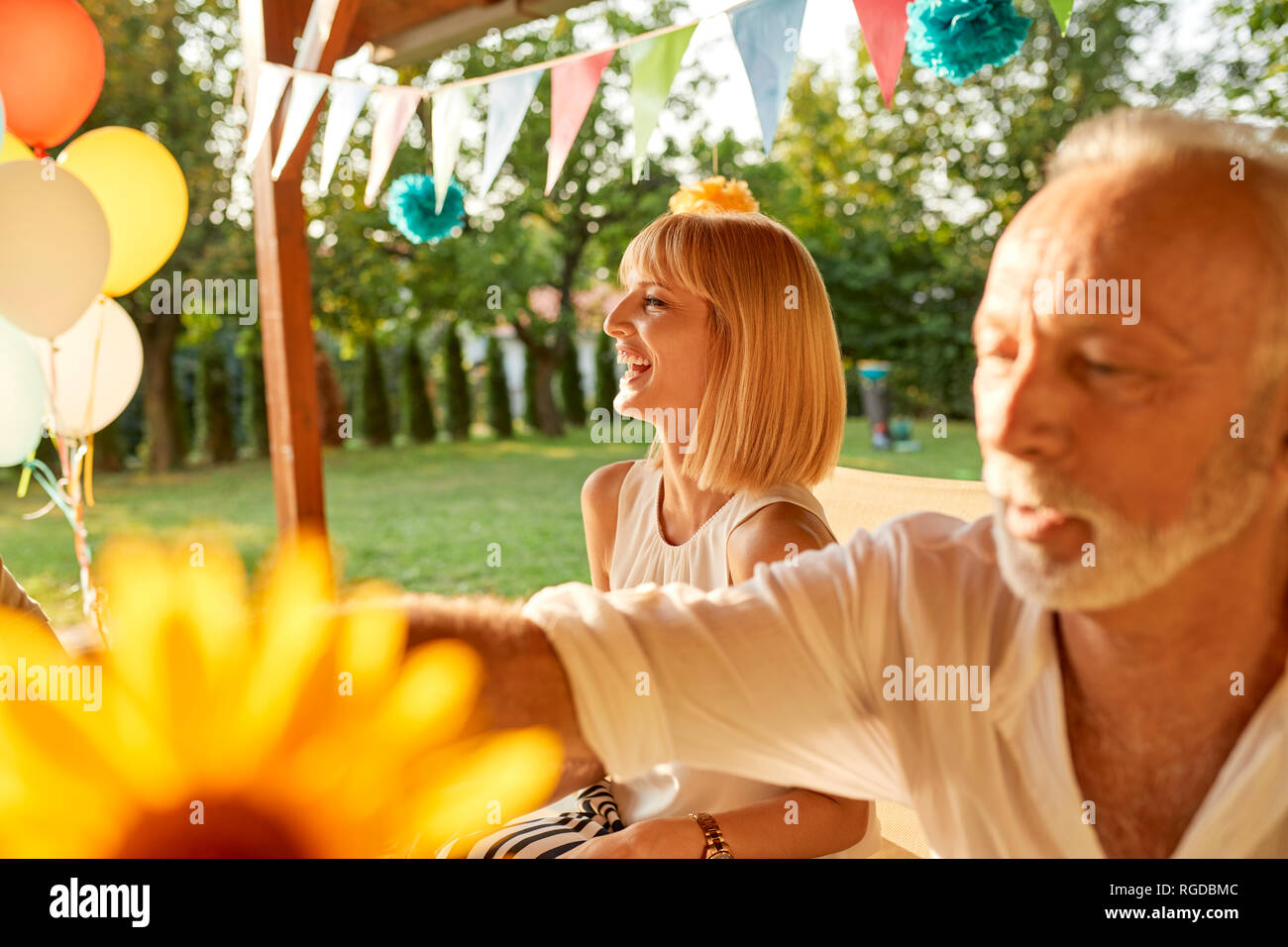 Glückliche Frau und älterer Mann auf einer Gartenparty Stockfoto