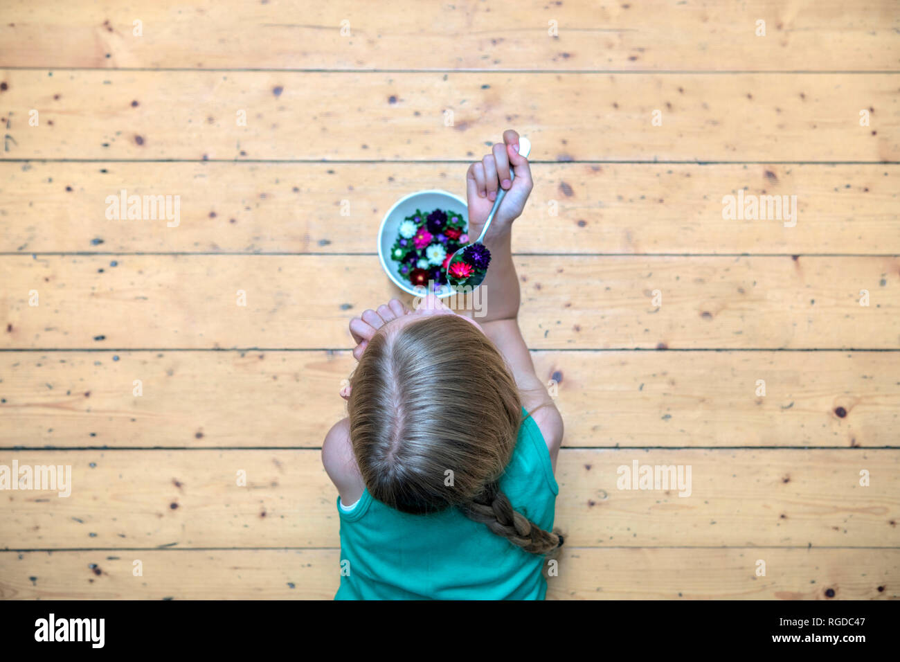 Mädchen liegt auf der Plank Stock mit Schüssel mit Blüten, Ansicht von oben Stockfoto