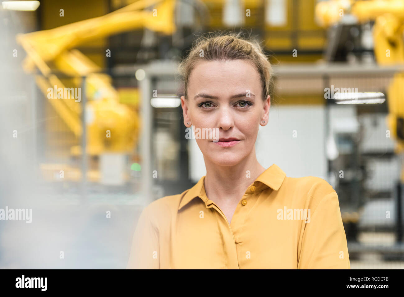 Portrait von selbstbewusste Frau in der Factory Shop Floor mit Industrieroboter Stockfoto