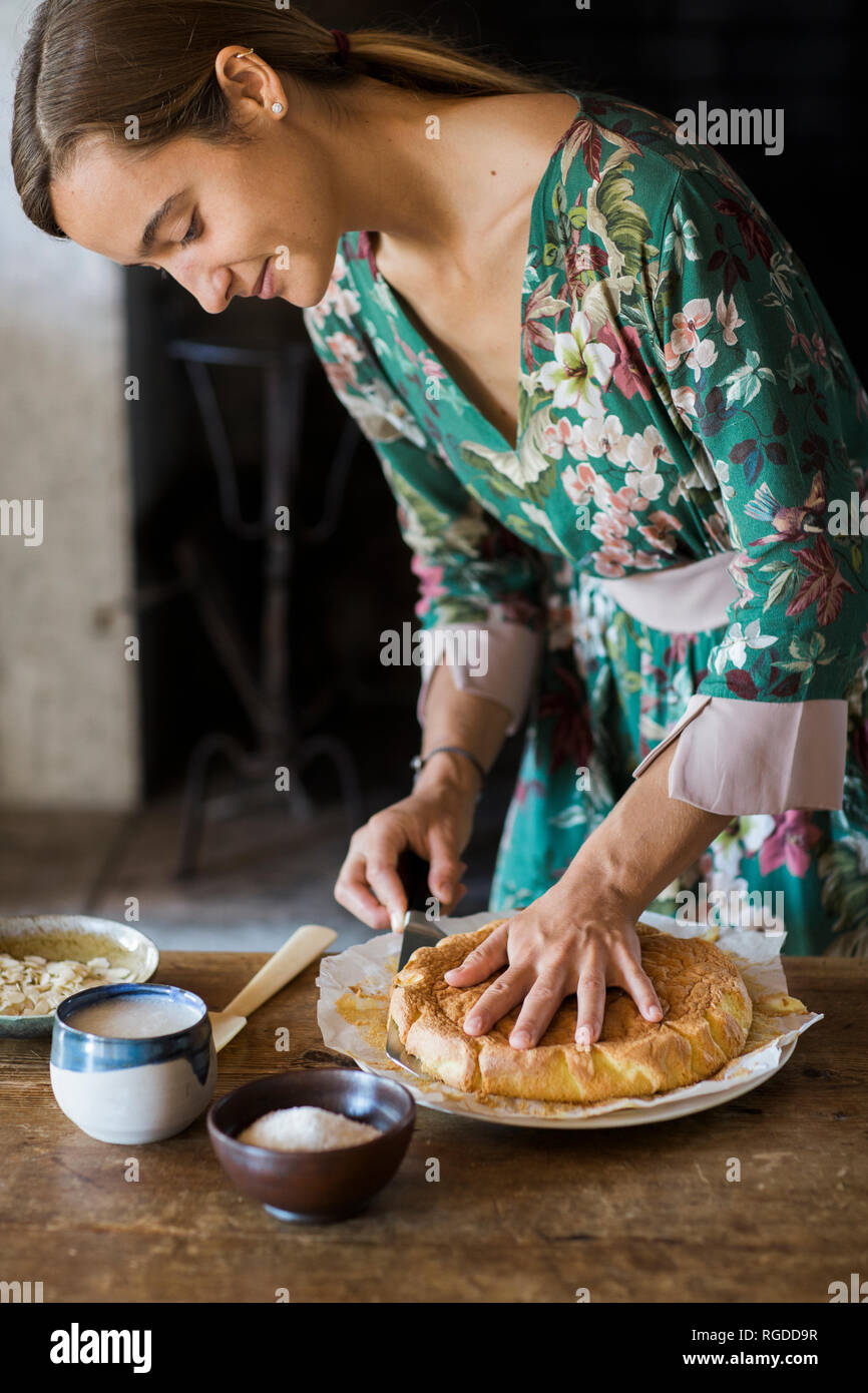 Junge Frau nach Hause schneiden - gebackene Kuchen Stockfoto