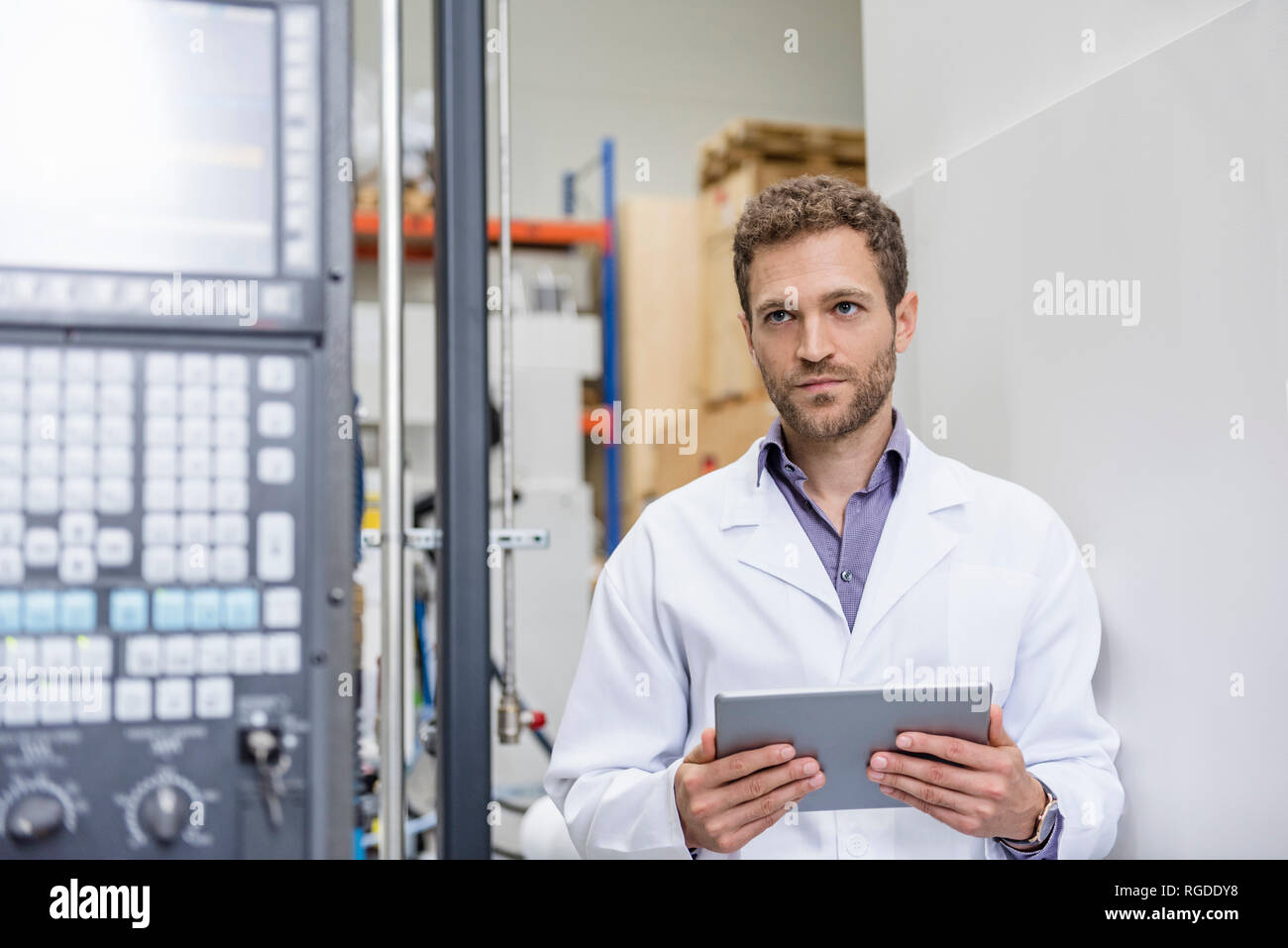 Mitarbeiter Kontrolle der Fertigung Maschinen in High Tech Unternehmen, indem Sie digitale Tablet Stockfoto