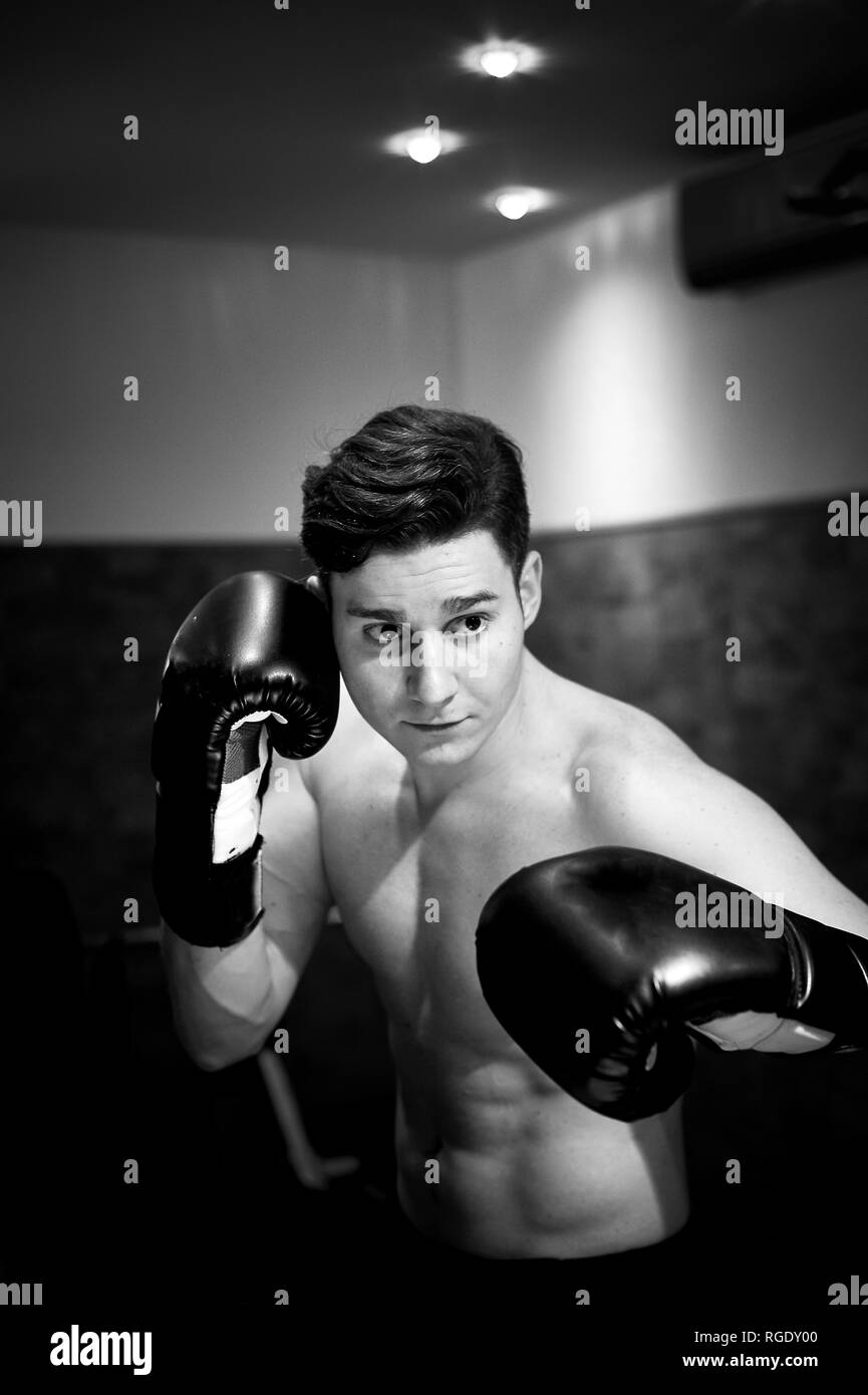 Ein junger Mann Züge im Boxen. Aggressivität, Sport und eine gesunde Lebensweise. Stockfoto
